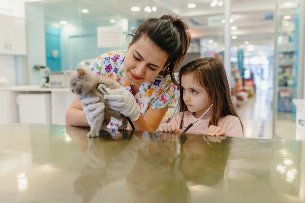 niña con gato y veterinaria