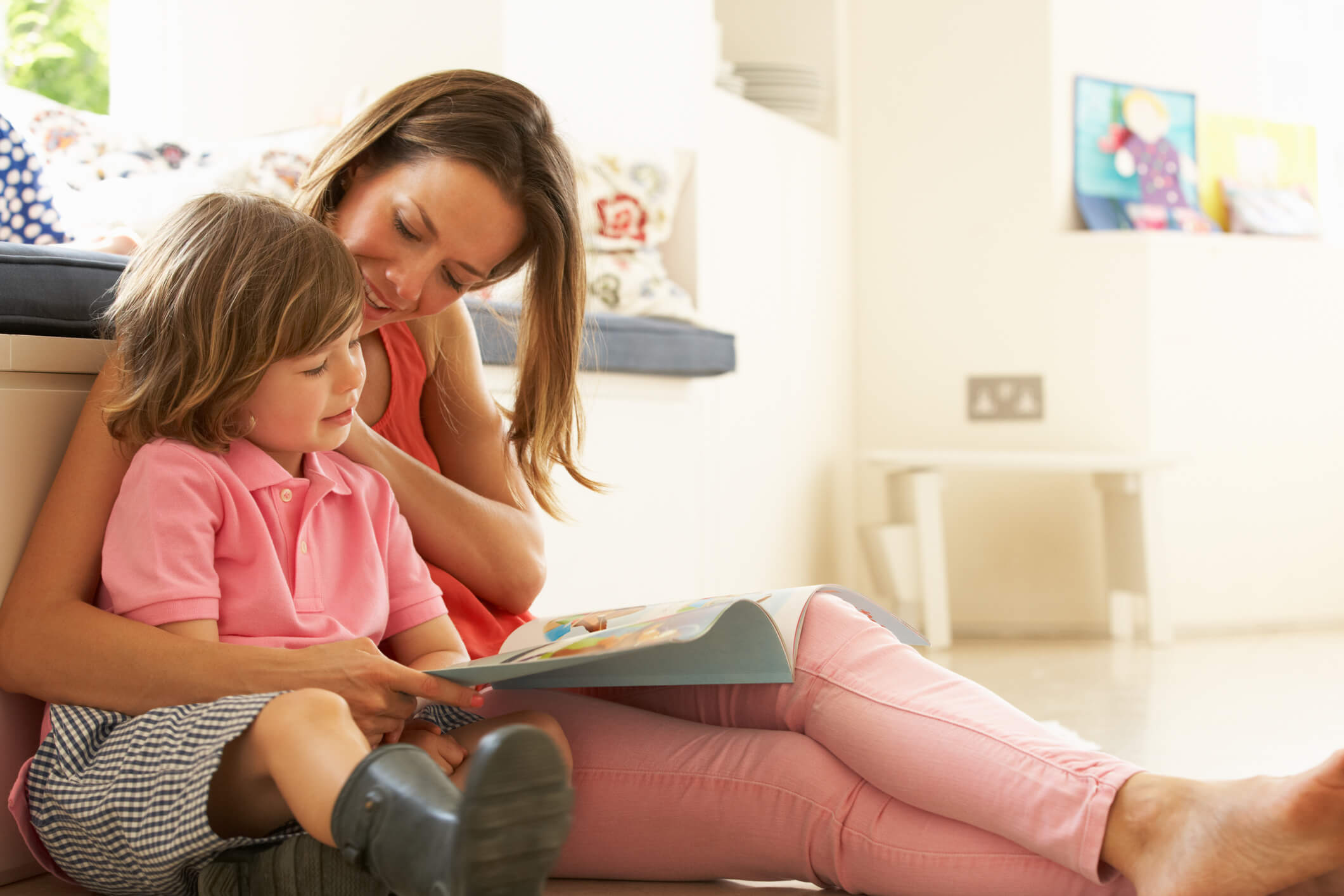 niña leyendo un libro junto a su mamá