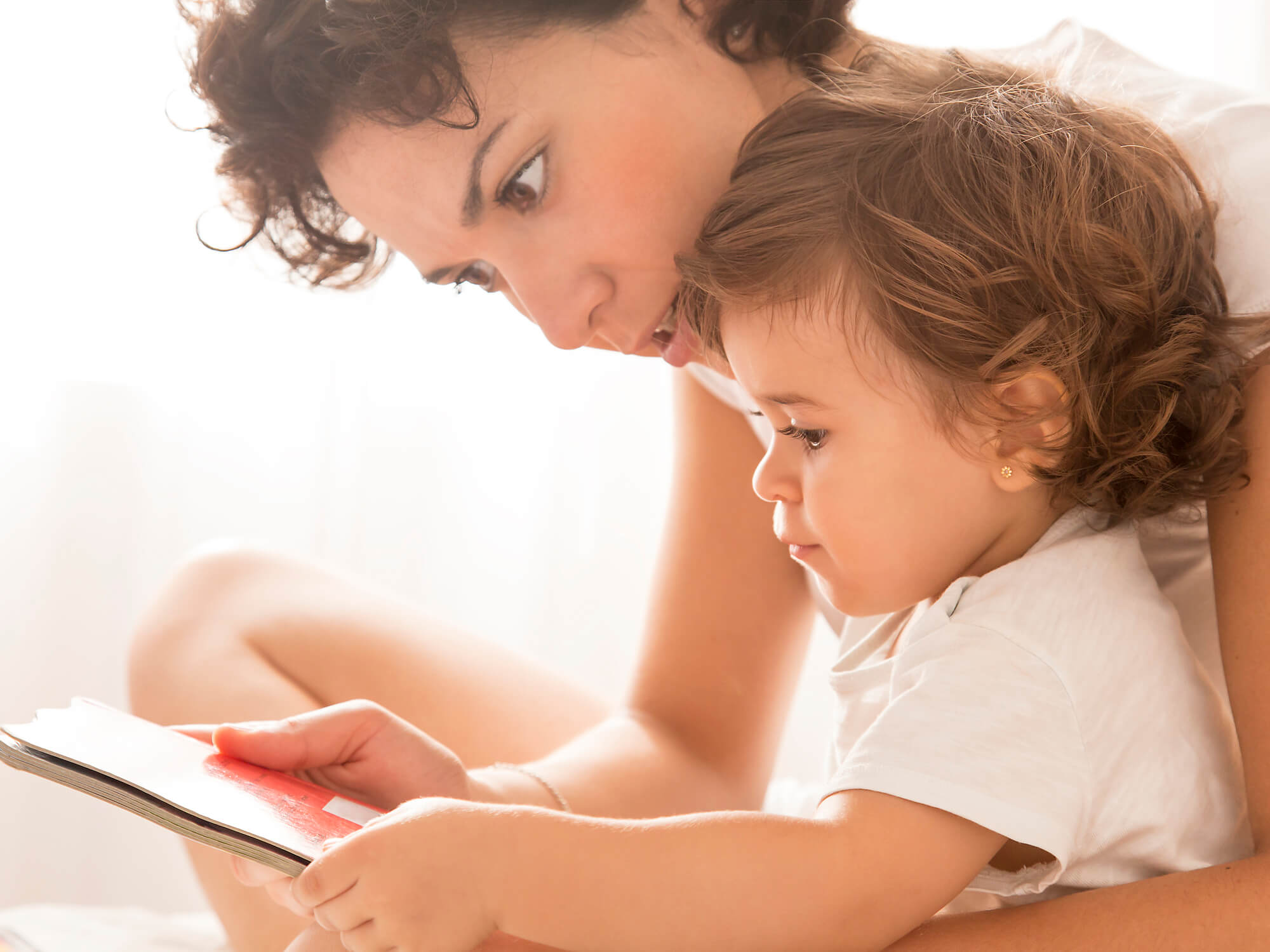 mamá con su hija bebé viendo un libro