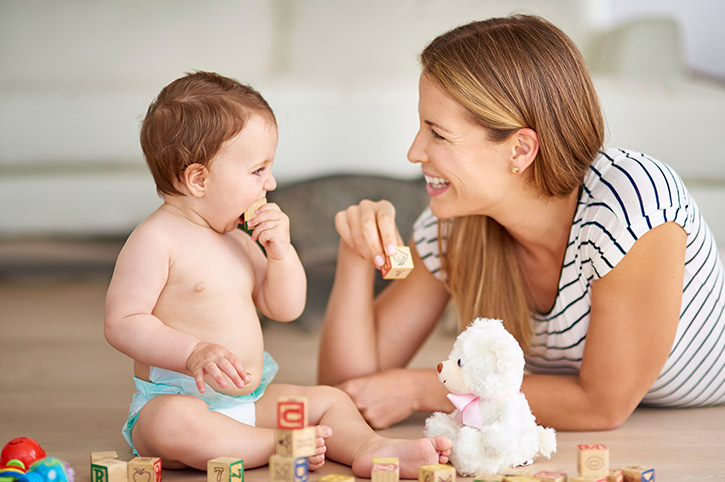 mamá con su bebé jugando en el piso