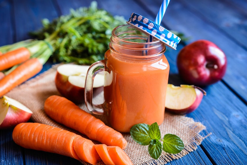 Jugo de naranja con frutas alrededor para prevenir resfriados
