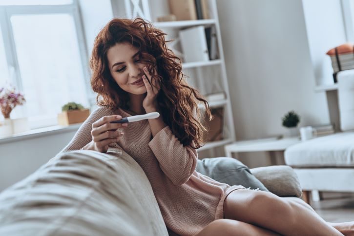 Mujer con prueba de embarazo positiva consiera los cuidados en el primer trimestre