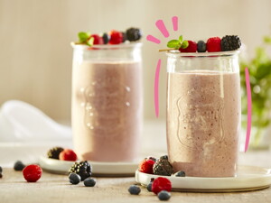 Vaso de smoothie de frutos rojos con frutos encima 