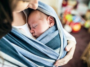 bebé sostenido por su mamá Uso seguro del portabebes