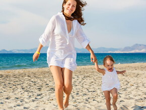 mamá-bebé-caminado-felices Mamá con bebe caminando y jugando en la playa cuidan de su salud