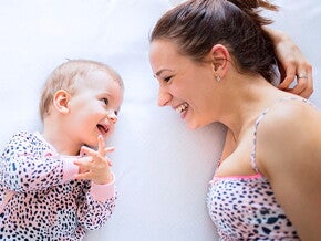 mamá-y-bebé-sonriendo-acostadas-en-la-cama mamá-y-bebé-sonriendo-acostadas-en-la-cama