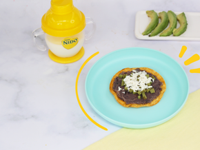 platos con tostadita mexicana y aguacate vaso entrenador con leche nido