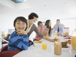 Familia el desayuno juntos en la cocina, sentados alrededor de la mesa.