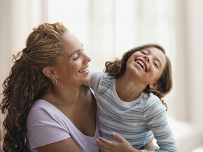 Mamá y niña de preescolar riendo al decir trabalenguas