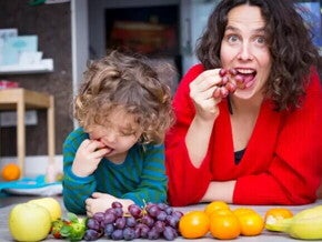 Mamá e hijo pequeño comiendo frutas con azúcar natural.