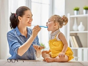 Mamá e hija compartiendo una alimentación saludable en casa.
