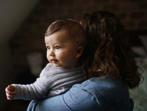 Bebé de 8 meses cargado por su mamá