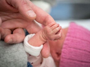Mamá cogiendo la mano de su bebé de un mes
