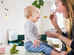 Mamá alimentando a su hijo con una papilla.