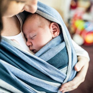 bebé sostenido por su mamá Uso seguro del portabebes