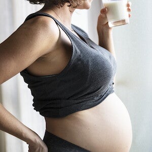 Mujer embarazada tomando un vaso de leche Mujer embarazada tomando un vaso de leche