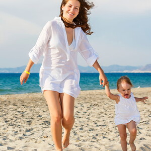 mamá-bebé-caminado-felices Mamá con bebe caminando y jugando en la playa cuidan de su salud