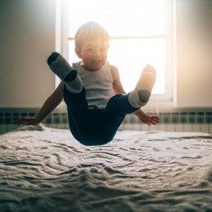 Estimulación temprana para bebés y niños niño saltando sobre la cama