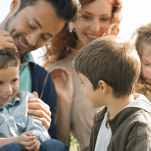 Beneficios y desafíos de las familias ensambladas Una linda familia disfrutando juntos en el césped con un niño