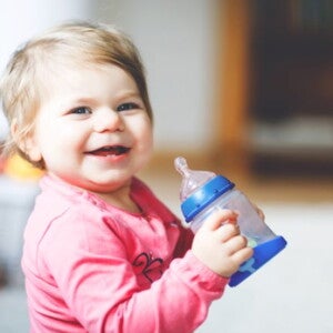 Niño bebiendo leche Niña sentada tomando un vaso de leche