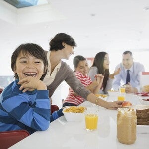 Familia el desayuno juntos en la cocina, sentados alrededor de la mesa.
