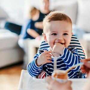 Guía para darle alimentos sólidos a tu bebé Bebé en su silla comiendo alimentos sólidos