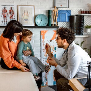 Pediatra revisando a niña con estomatitis