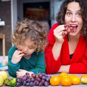 Mamá e hijo pequeño comiendo frutas con azúcar natural.