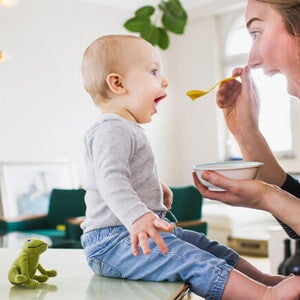 Conoce el desarrollo de tu bebé de 10 meses. Bebé de 10 meses sentado comiendo con mamá