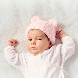 El fascinante mundo de tu bebé de 2 meses Bebé de dos meses acostada sobre la cama.