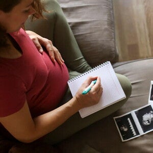 Tener un embarazo múltiple es muy común. Mamá con un cuaderno mirando la ecografía de su embarazo múltiple.