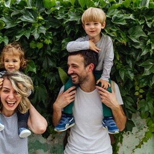 Estilos de crianza para educar a mi hijo Los padres riendo con los hijos alzados