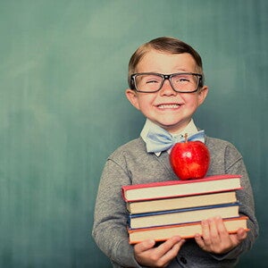 Conoce qué son las estrategias de aprendizaje. Niño sonriendo con libros en la mano.
