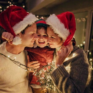 ¿Has pensado qué te gustaría para tu bebé? ¿Qué es lo que más deseas para él esta Navidad? Niño con sus padres adornando árbol de navidad