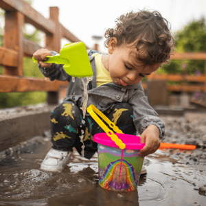Niño con buen sistema inmune jugando Niño con buen sistema inmunológico jugando con agua en el lodo