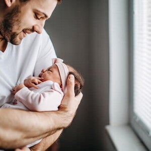 Los granitos en la cara de los bebés es un fenómeno común Papá alzando su bebé y revisando los granitos de su cara
