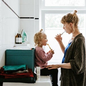 Conoce cuáles son los hábitos de higiene para niños. Mamá y niña en el baño cepillándose en el baño.