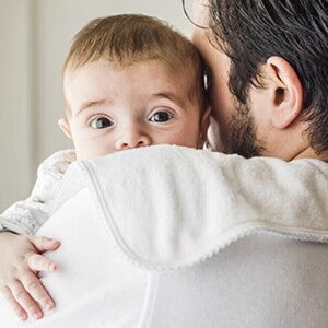 Reflujo en bebés Bebé con reflujo, apoyado sobre el hombro de su papá