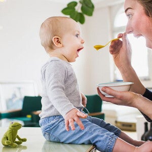 Conoce por qué son tan importantes los probióticos saludables en los niños. Mamá alimentando a su hijo con una papilla.