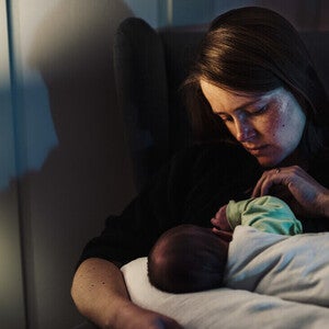 Mamá acostada dando de amamantar a su bebé, preocupada porque no come