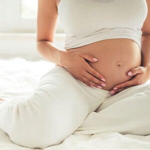 Conoce qué es el líquido amniótico y su función. Mamá tocando el vientre.