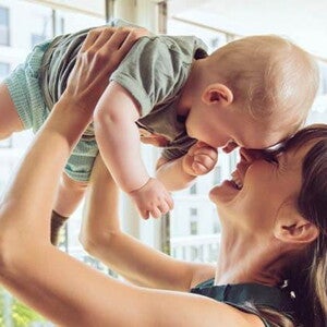 Conoce que es la curva de crecimiento y desarrollo. Mamá cargando a su bebé.