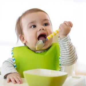 Tipos de baberos para bebés Bebé con babero comiendo