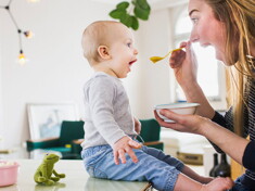 Mamá alimentando a su hijo con una papilla.