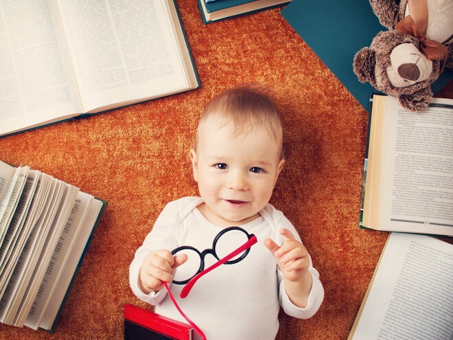Niño de un año con anteojos rodeado de libros Niño de un año con anteojos rodeado de libros