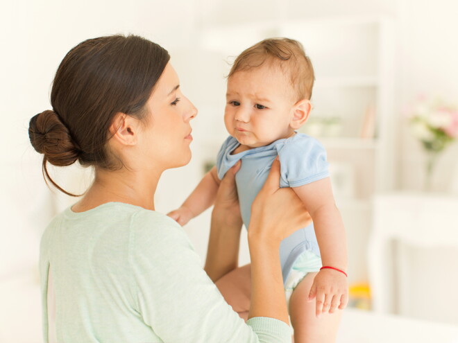 Mamá cargando a bebé con cólicos Mamá cargando a bebé con cólicos