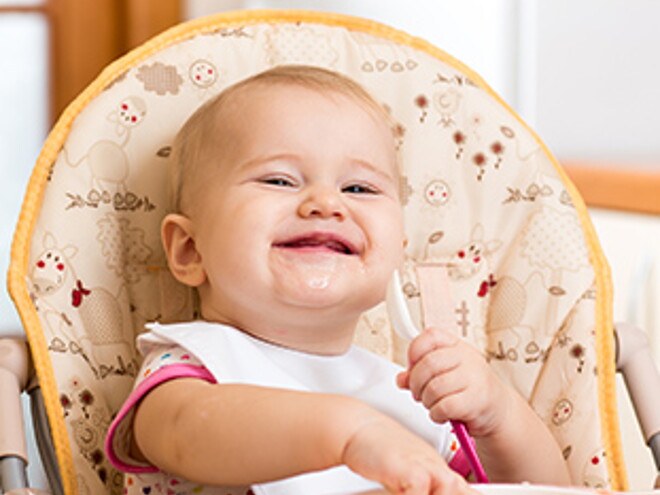 Papilla-de-verduras-y-pollo bebe sonriendo y comiendo alimentos para bebe de 9 meses