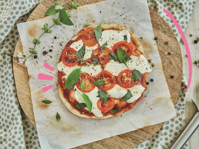 pizza margarita slim en tabla de corte junto a rebanador Las embarazadas pueden comer pizza