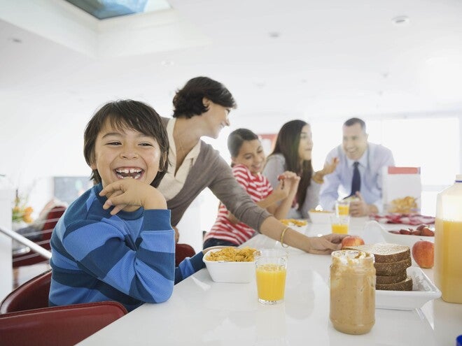 Familia el desayuno juntos en la cocina, sentados alrededor de la mesa.