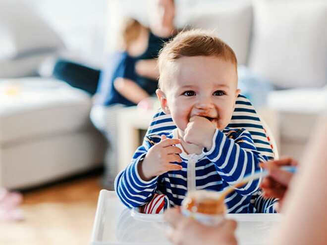 Guía para darle alimentos sólidos a tu bebé Bebé en su silla comiendo alimentos sólidos